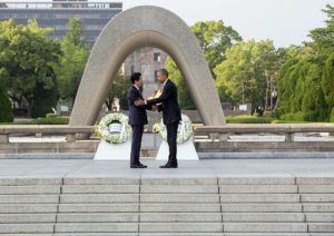 Japanese PM Shinzō Abe and US President Barack Obama shake hands at Hiroshima Peace Memorial Park, May 2016 (Photo by Pete Souza, public domain, via Wikimedia Commons)