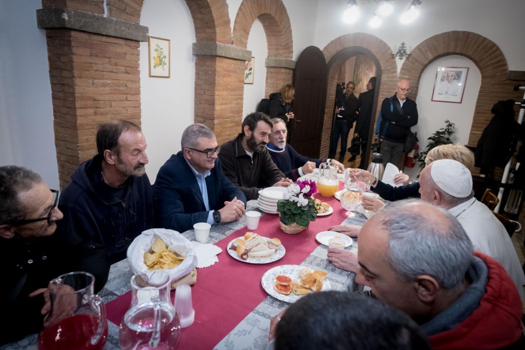 Pope Francis shares a meal with guests and volunteers of the "Palace of the Poor." 