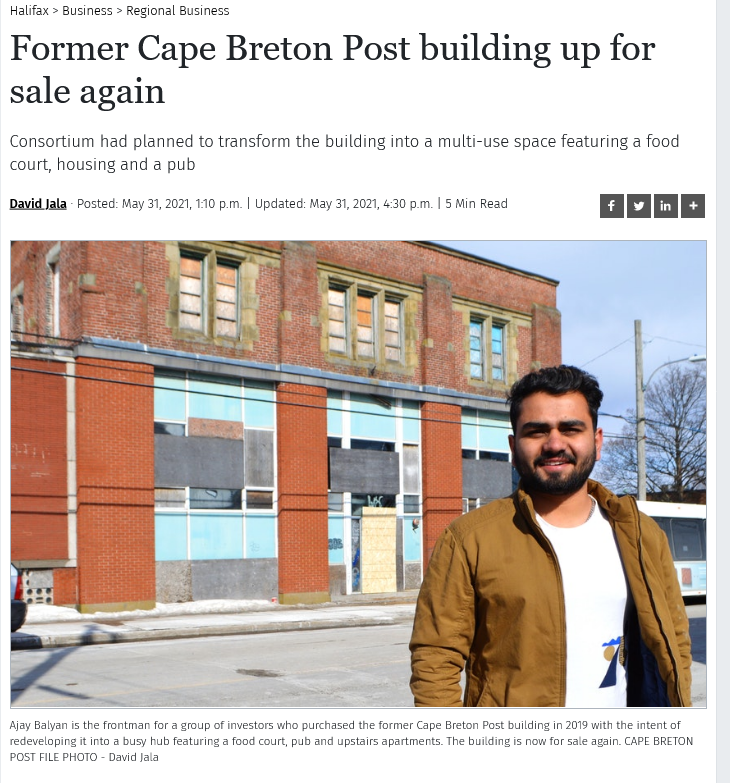 Photo of Ajay Balyan in front of old CB Post building in Sydney, NS