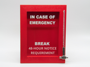 A photo of an alarm that reads "In case of emergency break 48-hour notice requirement"