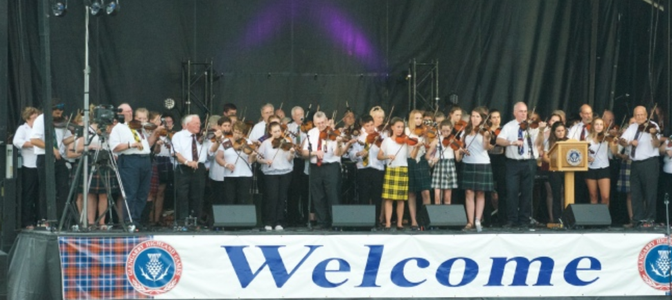 A photo of a group of fiddlers on a stage.
