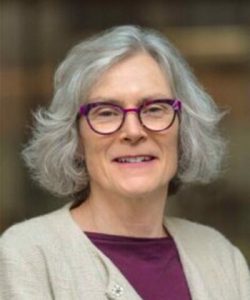 A photo of a woman with grey hair and glasses
